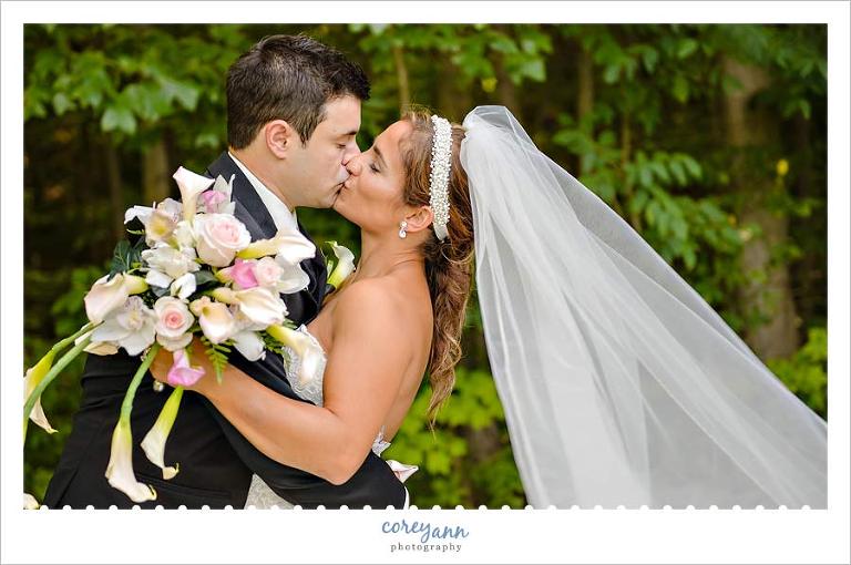 bride and groom kissing with veil behind them in ohio