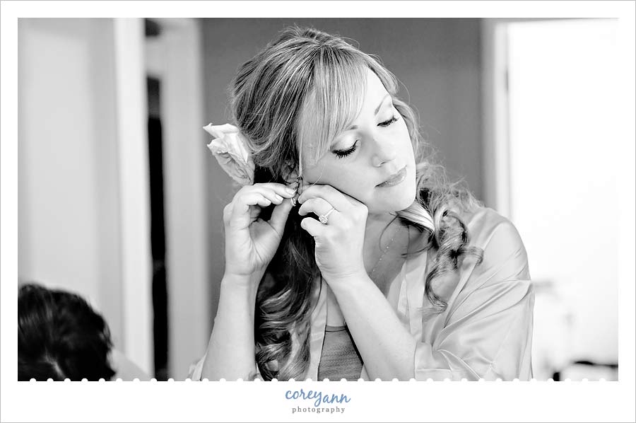 bride putting in earrings before wedding in ohio