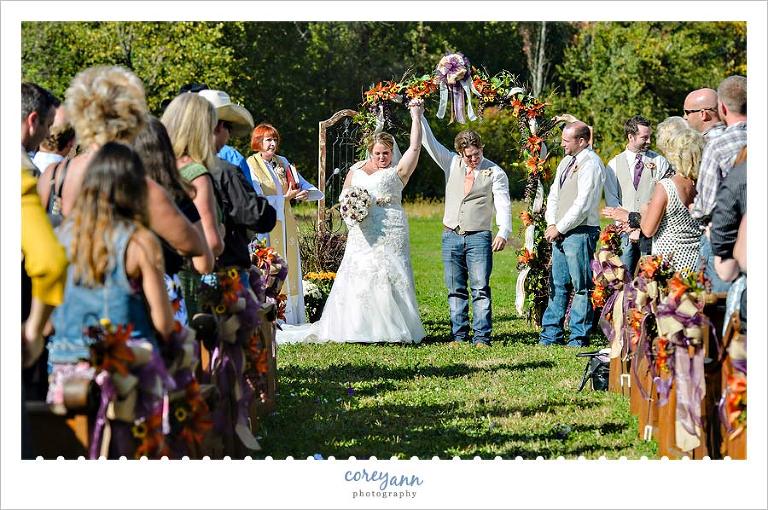 bride and groom raising arms after being pronounced man and wife