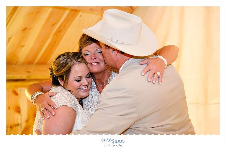 bride in a group hug with her parents after getting ready