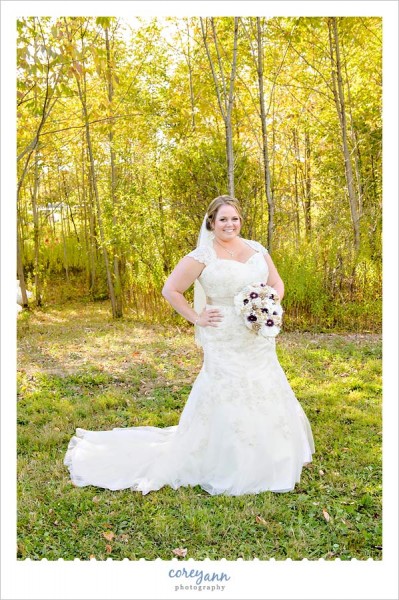 bride posing in sun drenched field