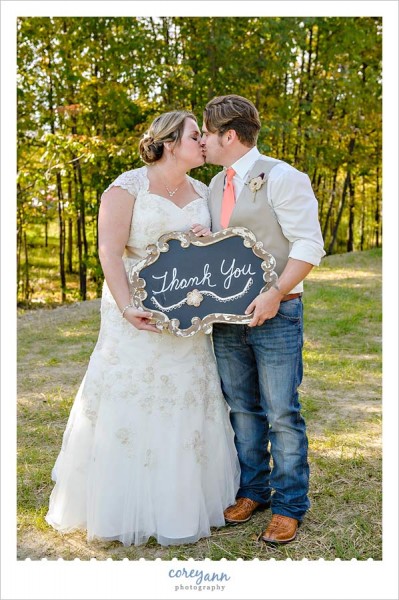 bride and groom with chalkboard thank you sign for cards
