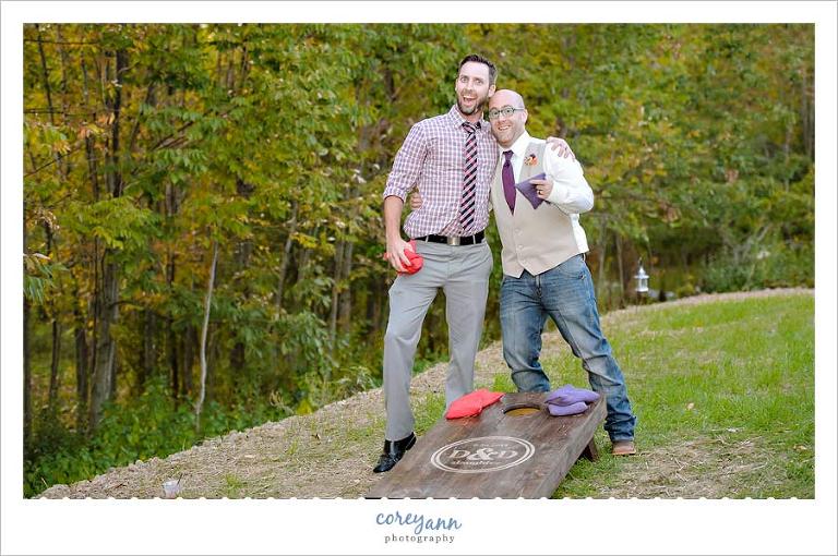 guests playing cornhole at wedding reception at a barn in september 