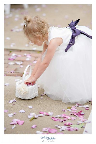 flower girl picking up petals during wedding ceremony