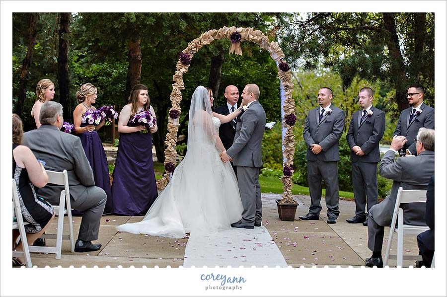 bride wiping tear from grooms eye after emotional wedding ceremony