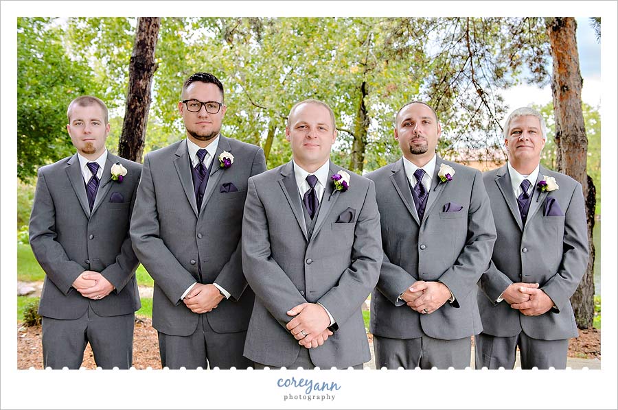 groom and groomsman in grey suits with purple ties