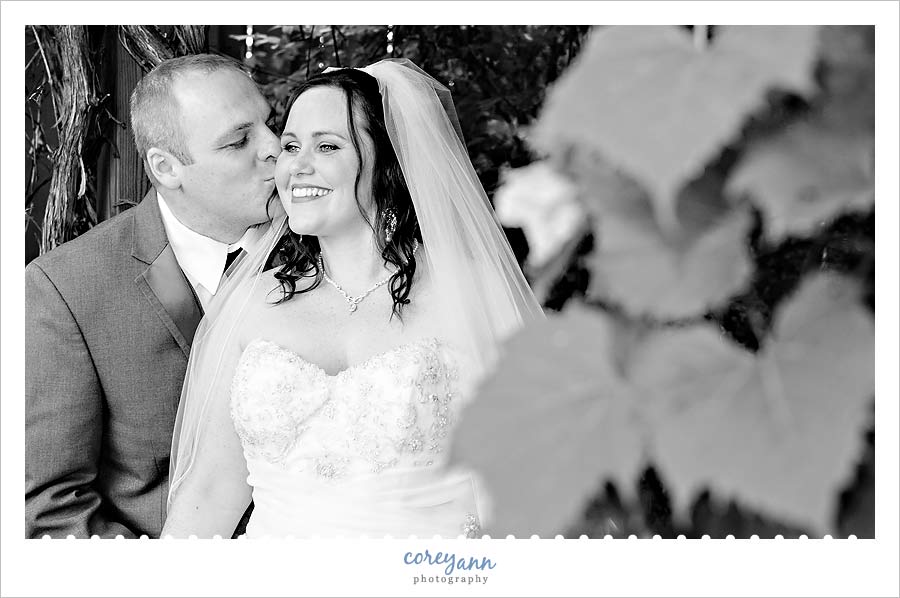 groom kissing bride's cheek after wedding at  williams on the lake