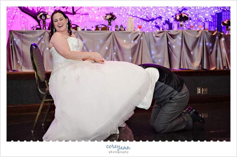 bride laughing at garter removal 
