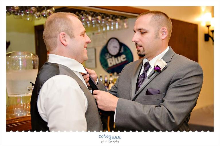 best man tying grooms tie before wedding in medina ohio