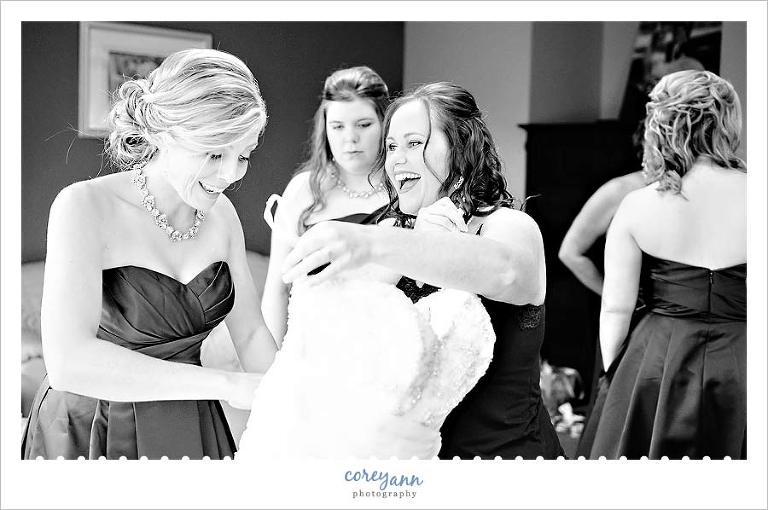 bride laughing with bridesmaids while getting ready for wedding