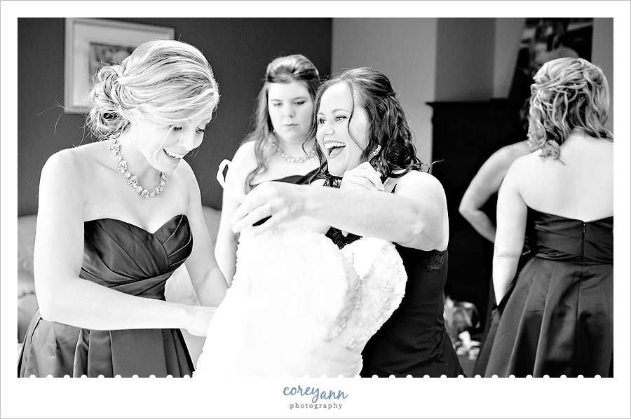 bride laughing with bridesmaids while getting ready for wedding