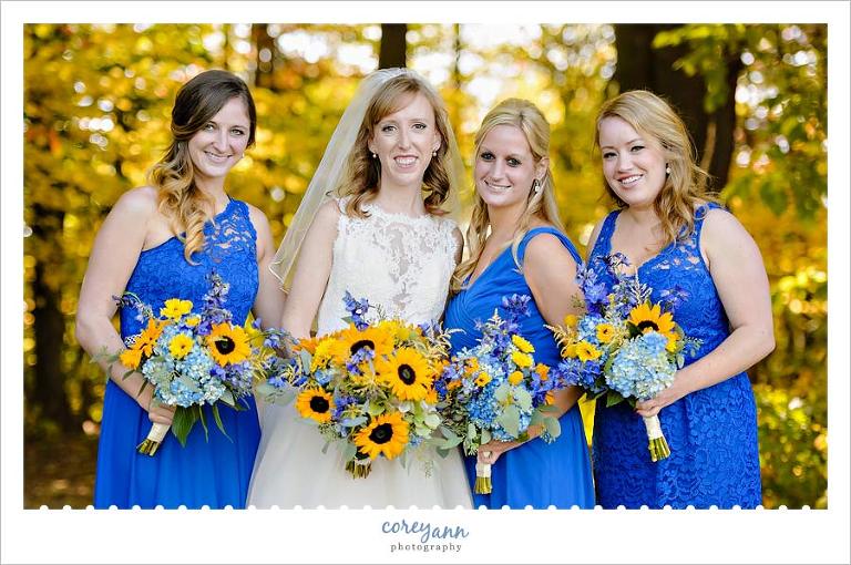 bride with bridesmaids in blue with yellow sunflower bouquets