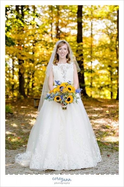 bride in the fall with yellow sunflower bouquet
