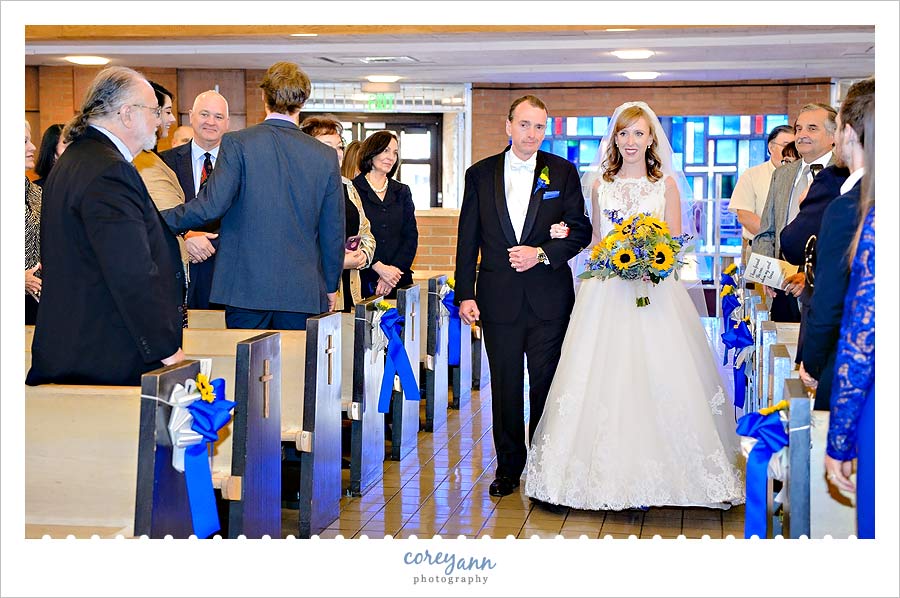 bride and father walking down aisle at holy family church