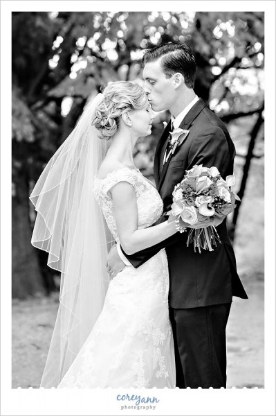groom kissing bride's forehead during wedding portraits at rocky river metropark