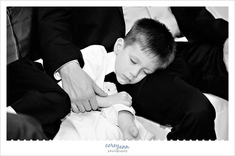 ring bearer asleep on a lap during wedding reception