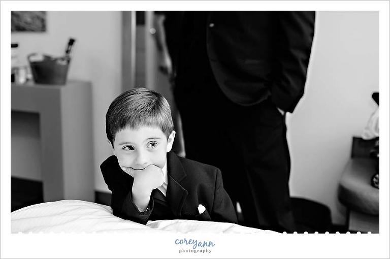 ring bearer watching his uncle the groom get ready for wedding