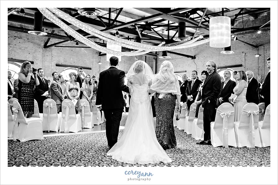 bride and parents walking up aisle at wedding ceremony at windows on the river