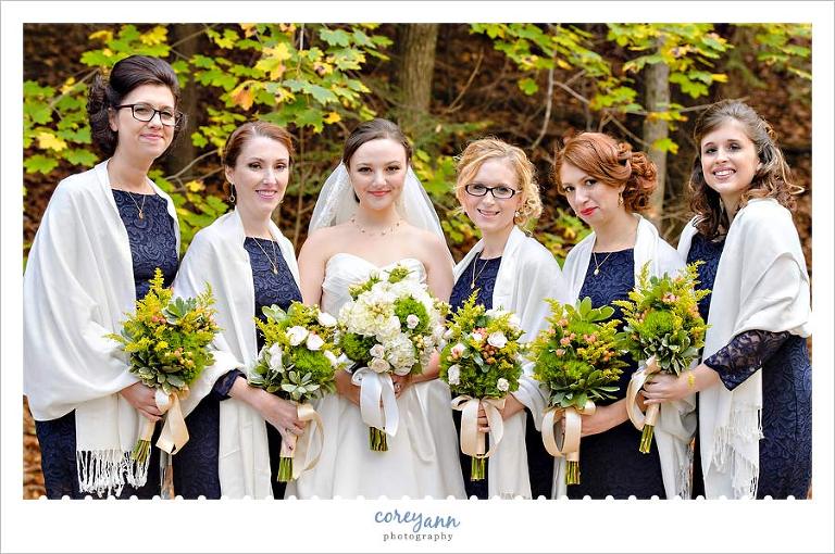 bridesmaids with short navy gowns and green and white bouquets