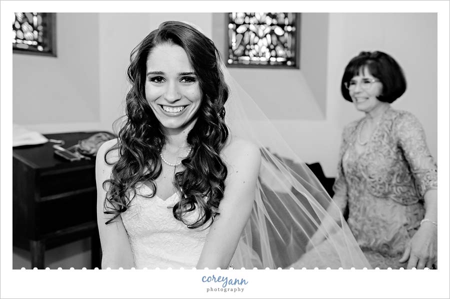 Mother putting veil on bride before wedding ceremony