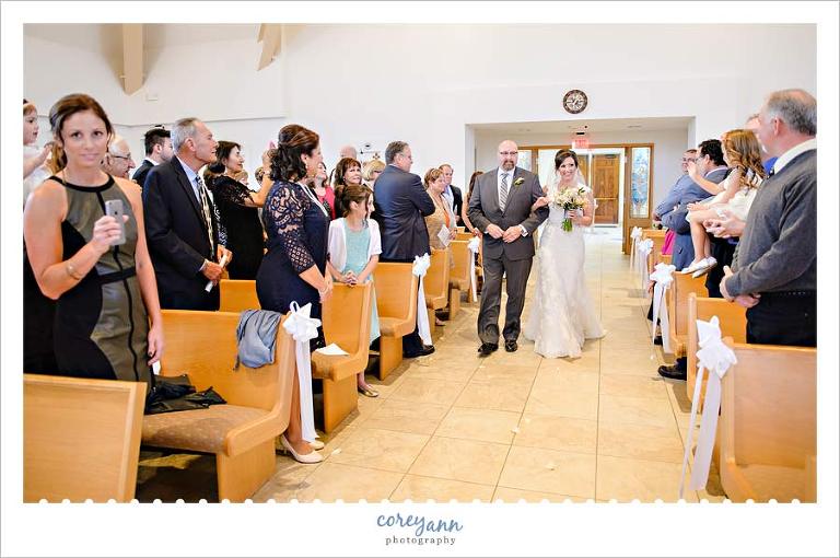 Bride and father walk up aisle at Walsh University in North Canton, OH
