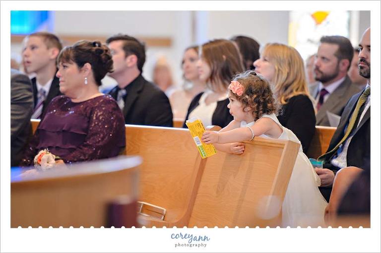 Flower girl holding candy and watching the wedding ceremony