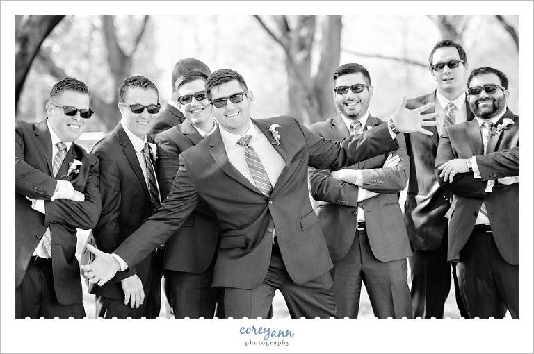 groom and groomsman laughing while posing for pictures