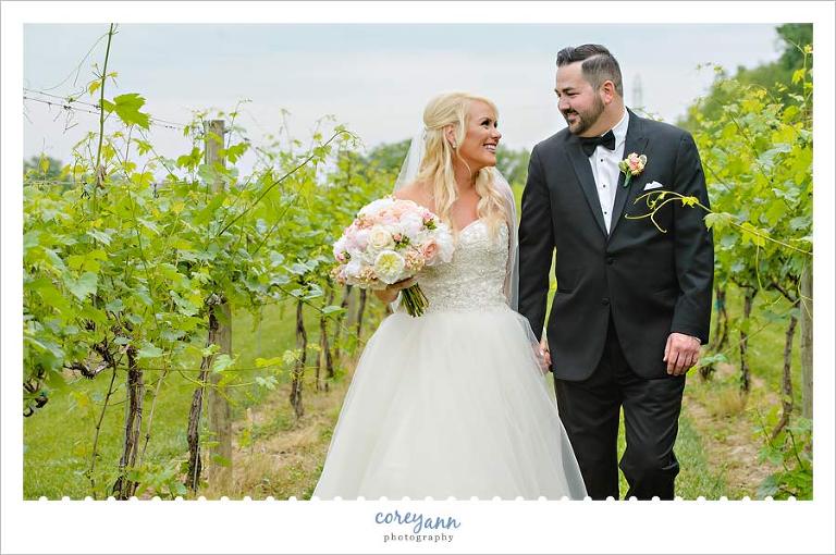 Bride and Groom walking in grape arbor in Ohio