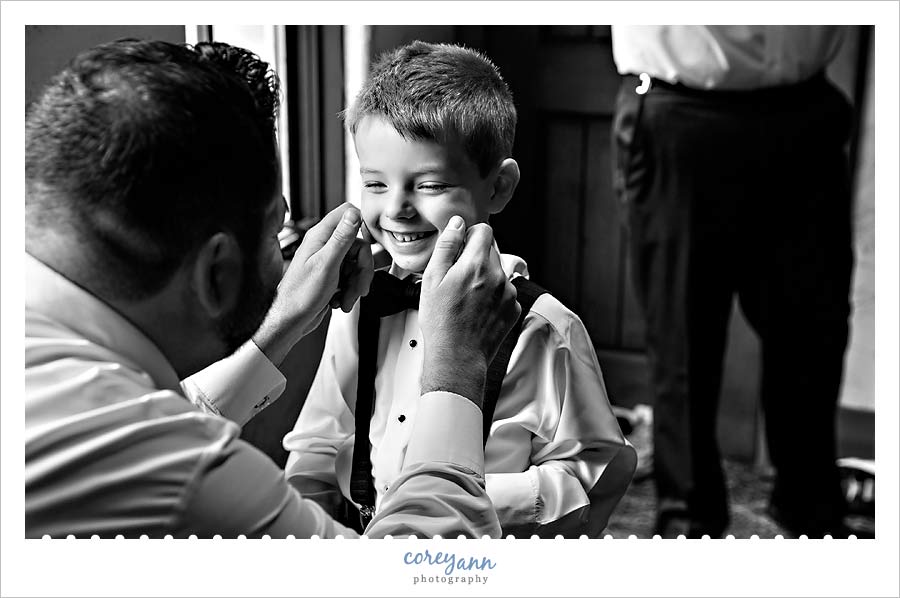 Groom getting ring bearer ready for wedding