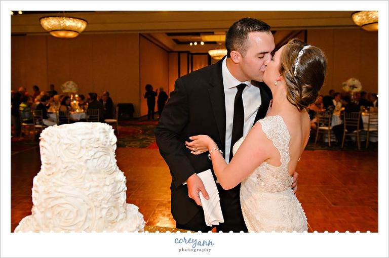 Kissing after cutting the cake at the cleveland marriot wedding reception