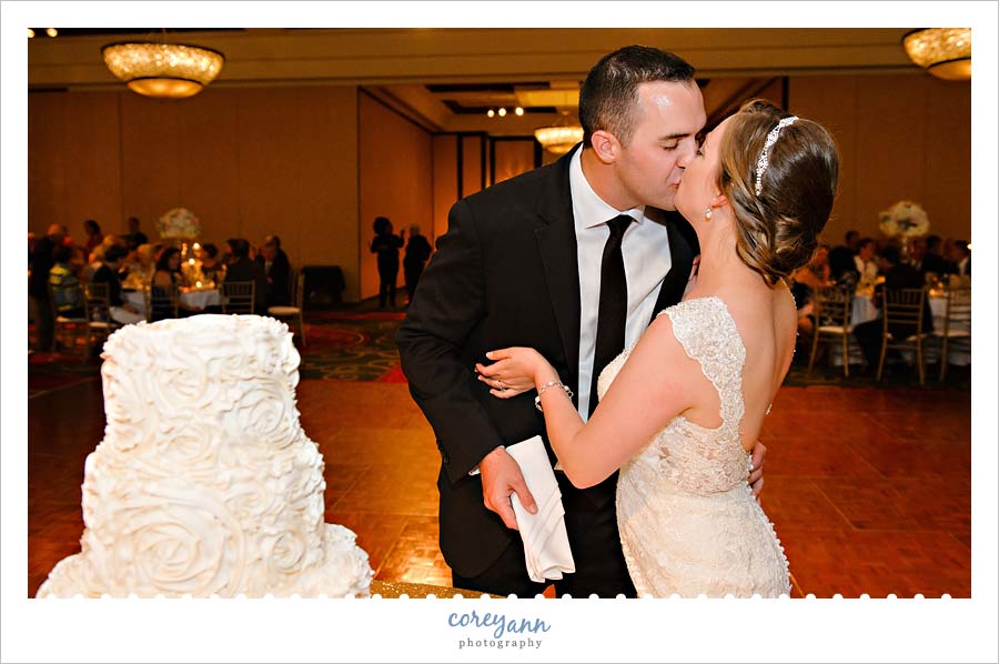 Kissing after cutting the cake at the cleveland marriot wedding reception