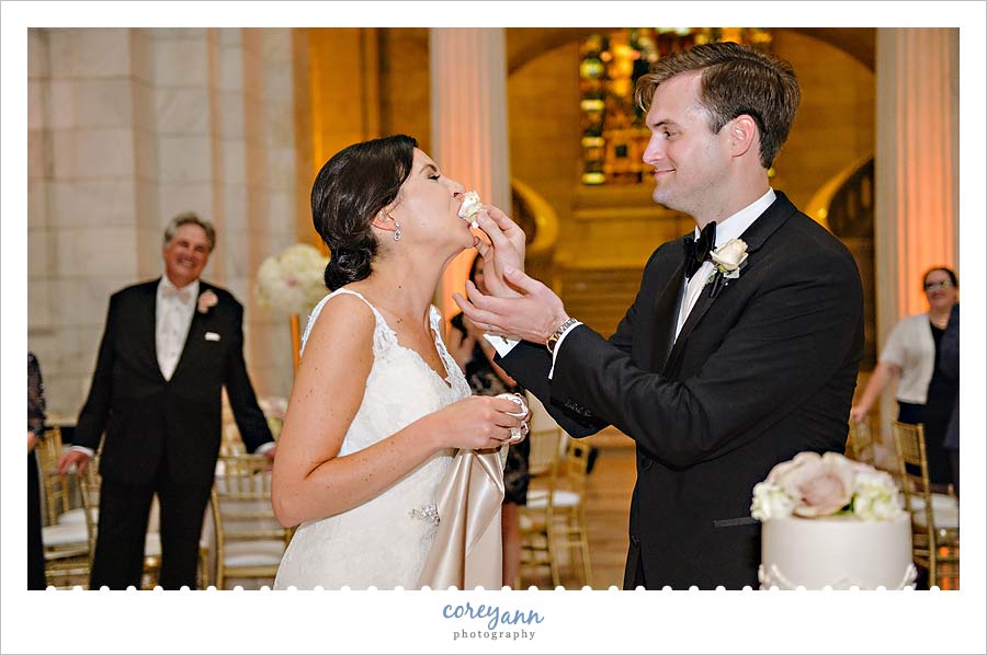Groom smashing cake in bride's face 