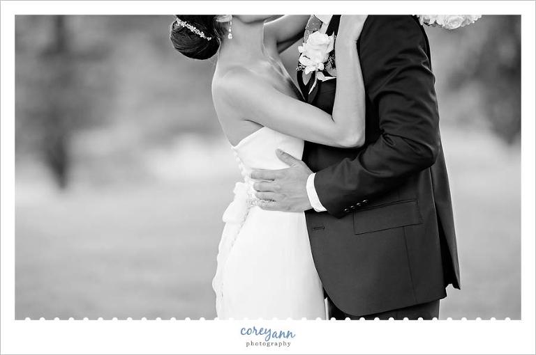 black and white wedding portrait of bride and groom kissing
