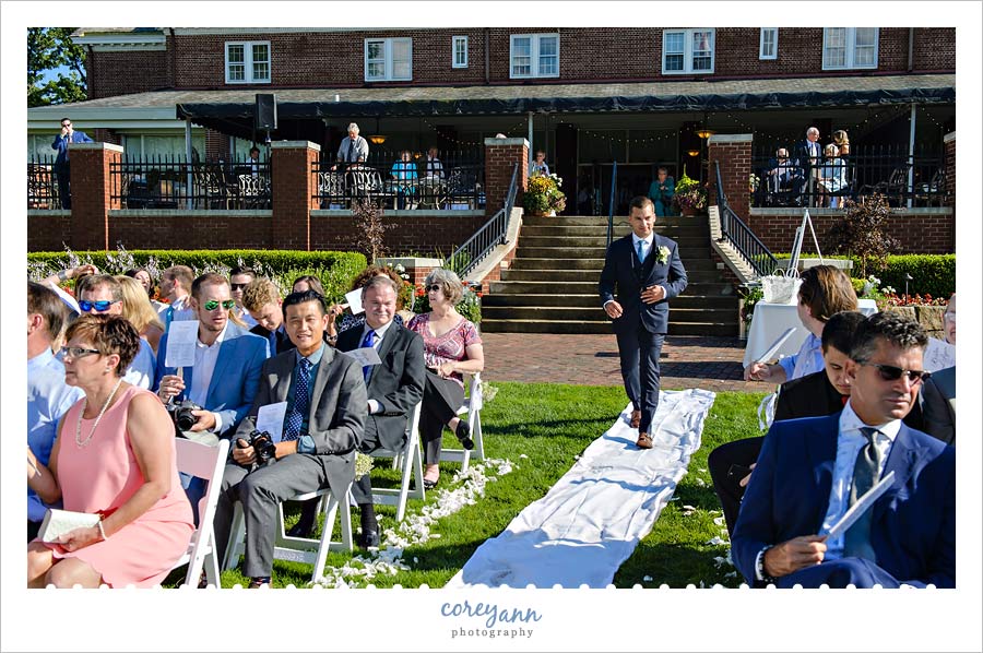 groom walking down aisle at wedding ceremony