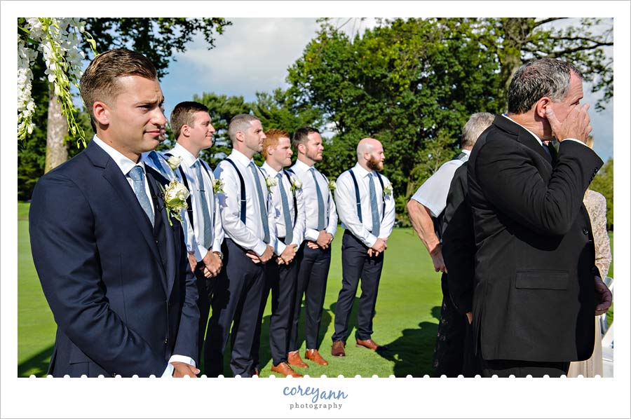 Groom watching bride walk down the aisle