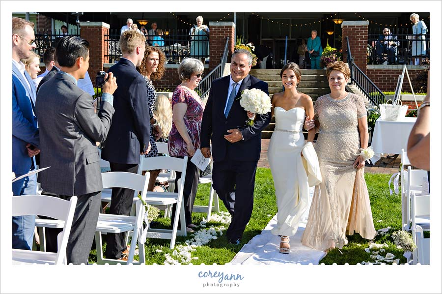 bride walking down the aisle with both parents