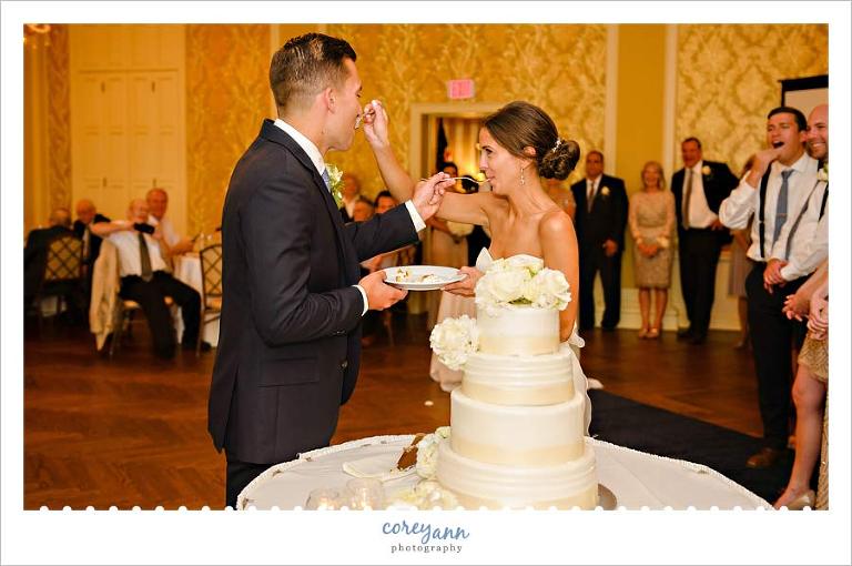 bride and groom eating cake at wedding reception
