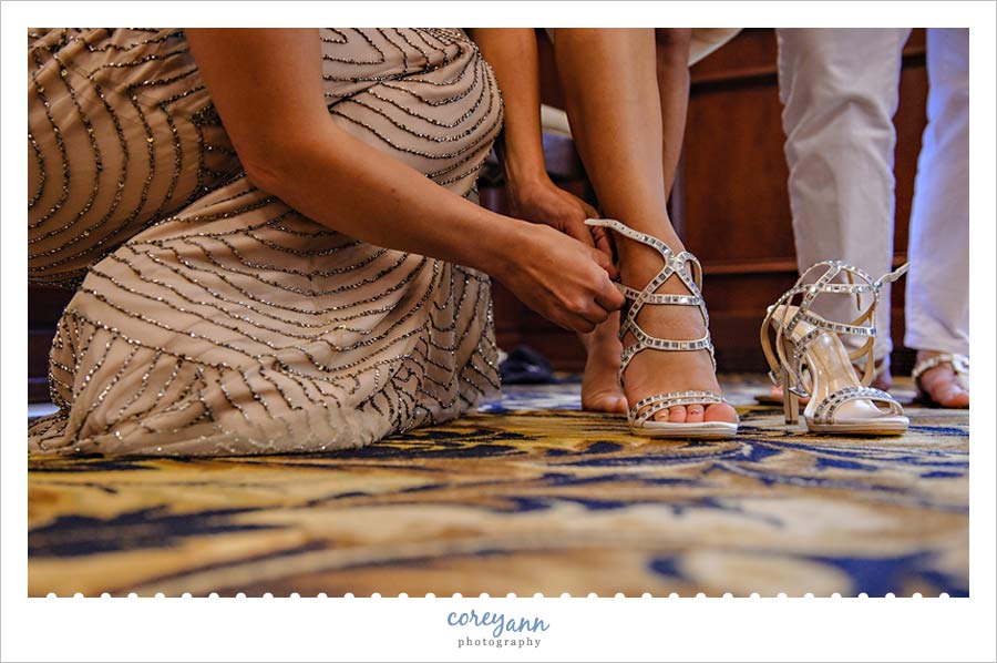 maid of honor helping bride with shoes 