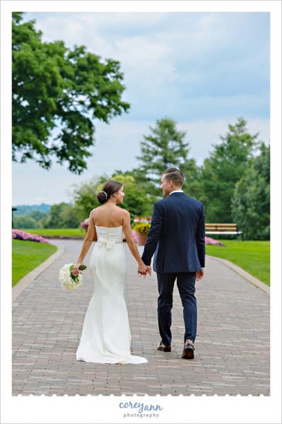 bride and groom walking on path at brookside country club