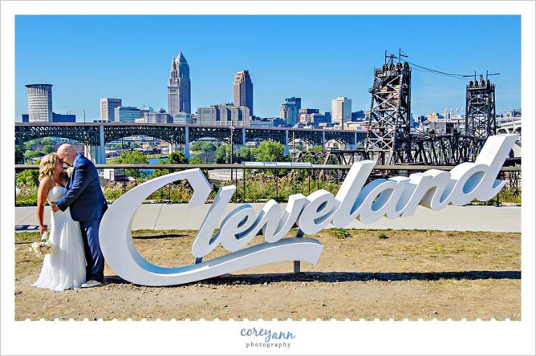 Bride and Groom pose near Cleveland sign in Tremont