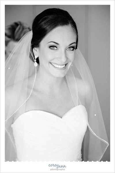 Bride smiling after getting veil placed in her hair