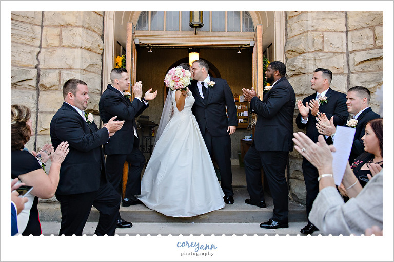 kissing while guests clap when exiting the church
