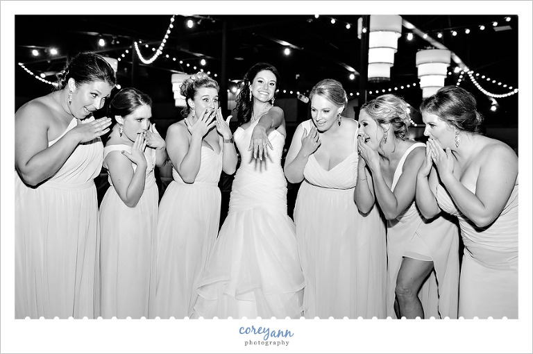 bride showing off wedding rings to bridesmaids