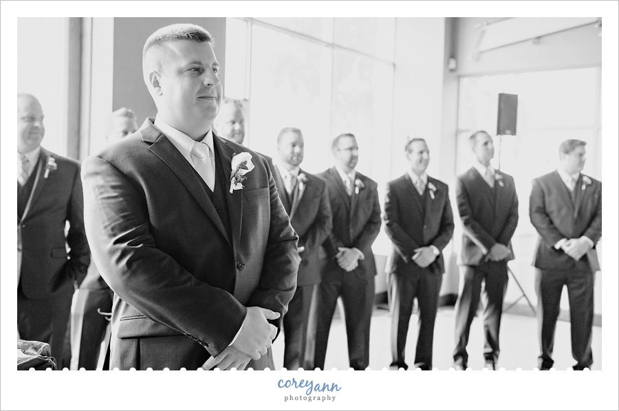 groom watching bride walking down aisle
