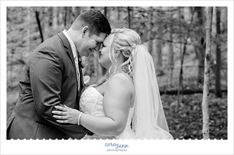 bride and groom touching noses in black and white photo