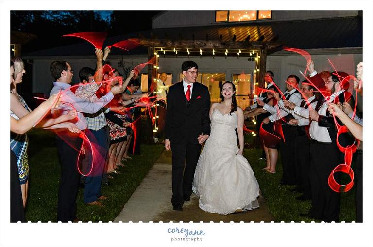 Bride and Groom Exiting with Red Glow Necklaces from Wedding Reception