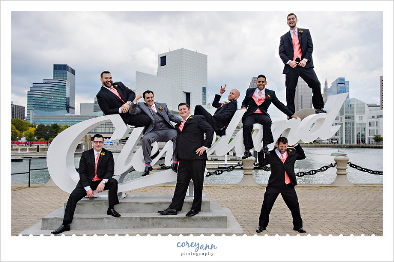 groomsman posing on the cleveland script sign in downtown cleveland