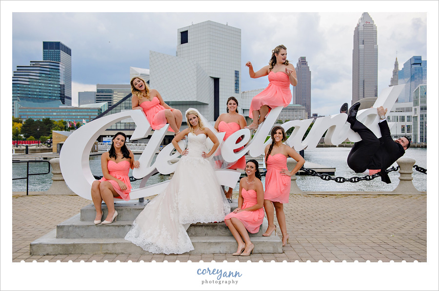 bridesmaids posing with bride on cleveland script sign