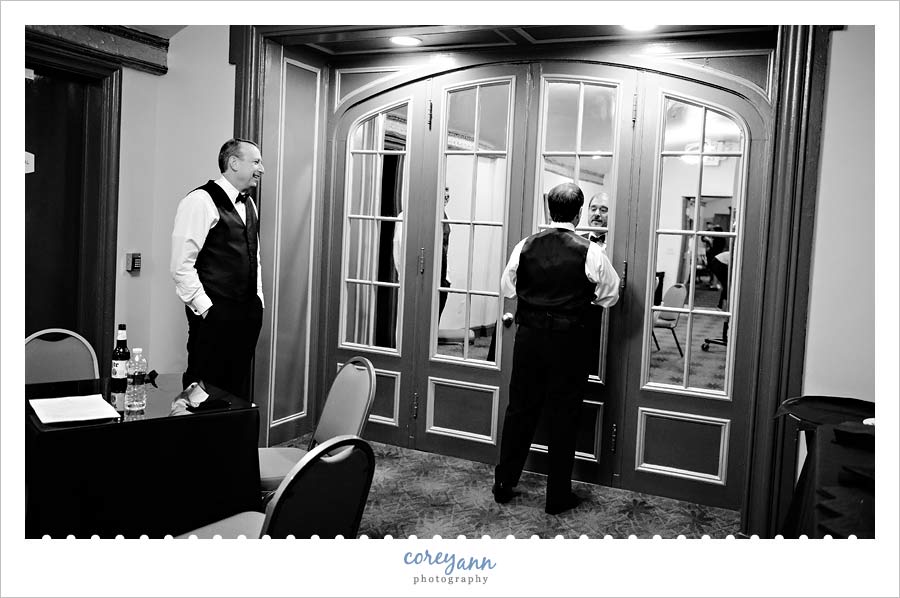 Groom straightening his tie before wedding