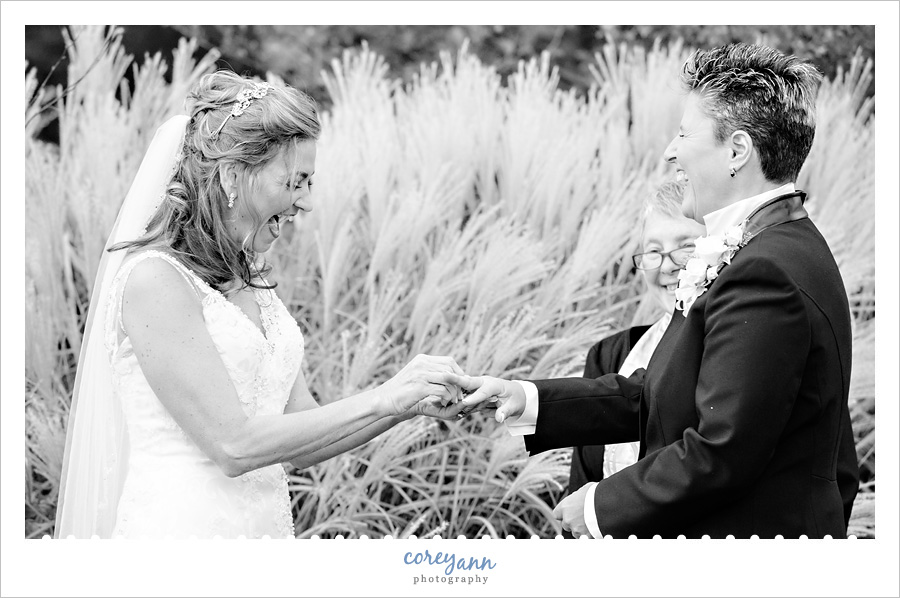 brides exchanging rings while laughing in the cleveland botanical gardens